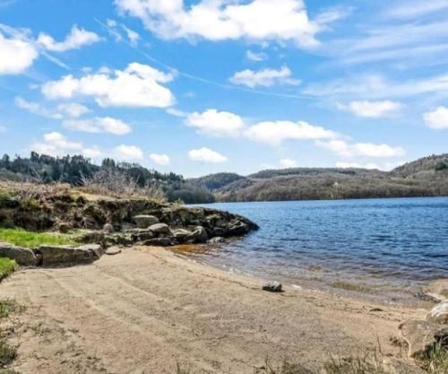 piaszczysta plaża obok zbiornika wodnego w obiekcie Gemütliches helles Ferienhaus am See mit Panoramaseeblick + Hütte und nahe Meer w mieście Lyngdal