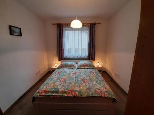 ein kleines Schlafzimmer mit einem Bett und einem Fenster in der Unterkunft 42 féröhelyes apartman in Balatonlelle