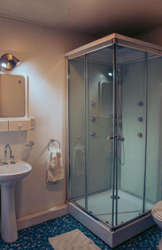 a glass shower in a bathroom with a sink at KooColand-Container con mini pileta in Tupungato