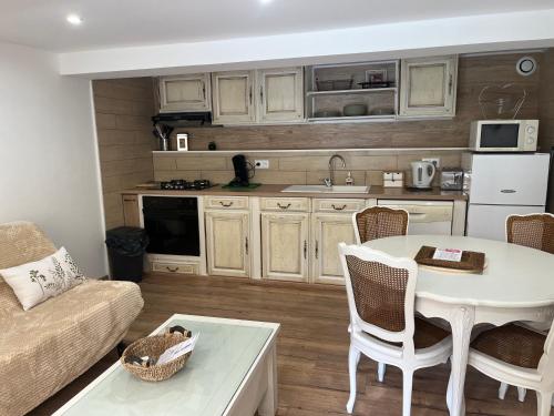 a living room with a table and a kitchen at L'intemporel in Gourdan-Polignan