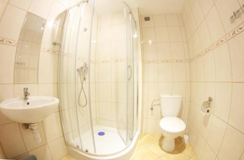 a bathroom with a shower and a toilet and a sink at Apolonia in Dziwnów