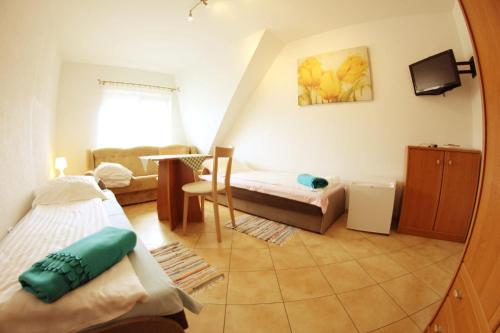 a small room with two beds and a living room at Apolonia in Dziwnów