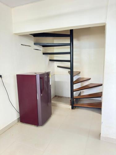 a kitchen with a staircase and a refrigerator in a room at MANNAT VILLA 2bhk in Daman