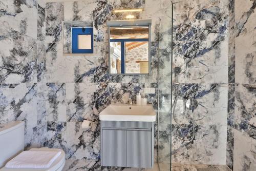 a bathroom with a sink and a glass shower at Villa Flower Blue Patara in Gelemiş