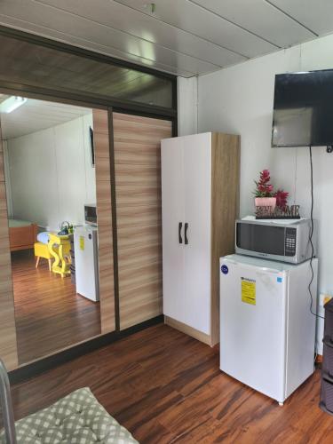 a living room with a refrigerator and a tv at Bonvivant Boquete in Alto Boquete