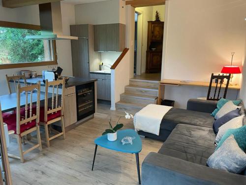 een woonkamer met een bank en een keuken bij Chalet d'Ayral avec jardin privatif in Leysin