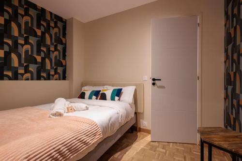 a bedroom with a large bed and a door at Le VB du 21 in Bourg-en-Bresse