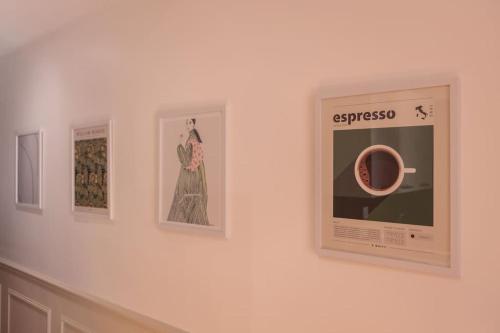 a wall with pictures of a dress and a cup of coffee at Le VB du 21 in Bourg-en-Bresse