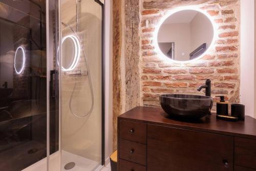 La salle de bains est pourvue d'un lavabo et d'une douche en verre. dans l'établissement Le VB du 21, à Bourg-en-Bresse