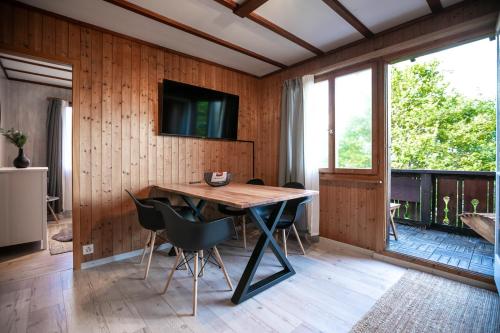 a dining room with a table and chairs and a television at Grubenmann Appartements - Flumserberg mit Bergpanorama in Flums