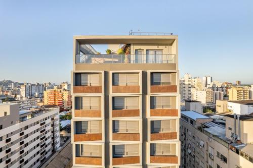 a building with a balcony on top of a city at Studio JP Redenção in Porto Alegre