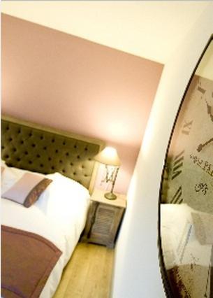 a hotel room with a bed and a mirror at Hôtel du Haut Koenigsbourg- entre vignes et château in Thannenkirch