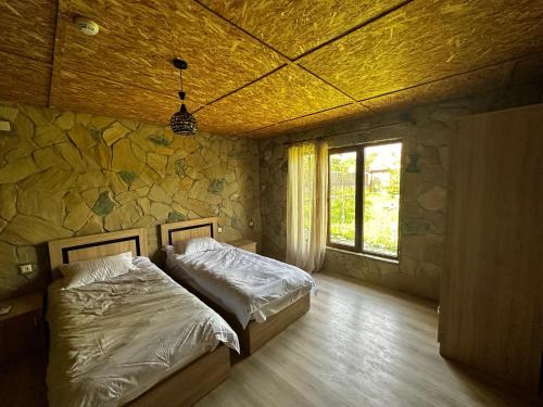 クタイシにあるOld Marani hotel, Tskaltuboの石壁のベッドルーム1室(ベッド1台付)