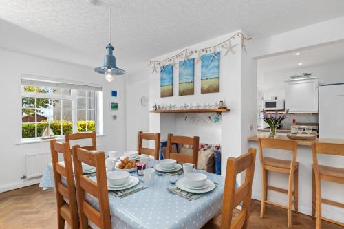 una cucina e una sala da pranzo con tavolo e sedie di Ruby Cottage - Beachside Cottage with Views a Saundersfoot