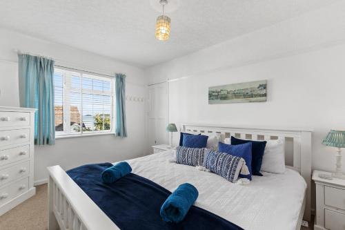 una camera da letto con un letto grande con cuscini blu di Ruby Cottage - Beachside Cottage with Views a Saundersfoot