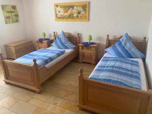 two beds in a room with blue pillows at Ferienhof Klein in Gunzenhausen