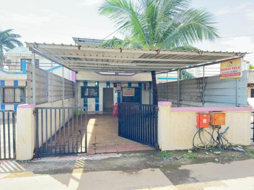 an entrance to a building with a gate and a palm tree at MANNAT VILLA 2bhk in Daman