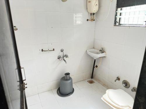 a small bathroom with a toilet and a sink at MANNAT VILLA 2bhk in Daman