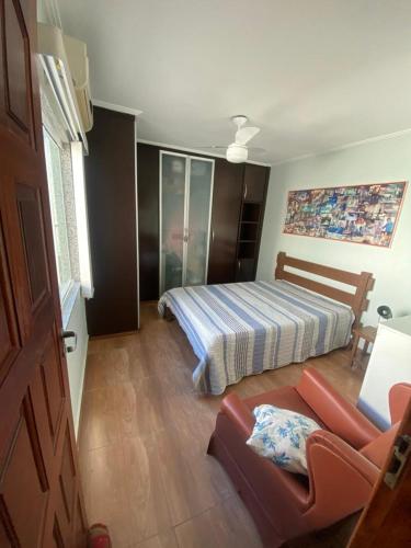 Un dormitorio con una cama y un sofá en una habitación. en Portal dos Anjos - Casa 03, en Arraial do Cabo