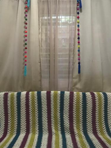 a curtain with colorful beads on it next to a window at Recámara en casa estilo boho in Chiapa de Corzo