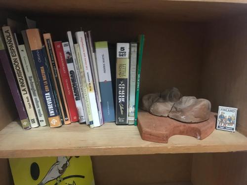 a book shelf with a bunch of books and a statue at Recámara en casa estilo boho in Chiapa de Corzo