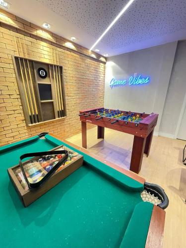 a ping pong table in a room with a pool table at Espaço ´ike SUNNY HALL Porto de Galinhas/PE (café da manhã opcional) in Porto De Galinhas