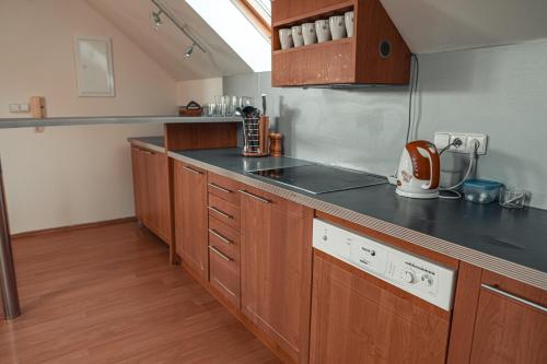 a kitchen with wooden cabinets and a counter top at Penzion Hurikán 63 in Havlíčkŭv Brod