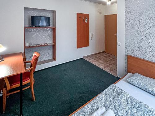 une chambre d'hôtel avec un lit, une table et une chaise dans l'établissement Penzion Hurikán 63, à Havlíčkův Brod