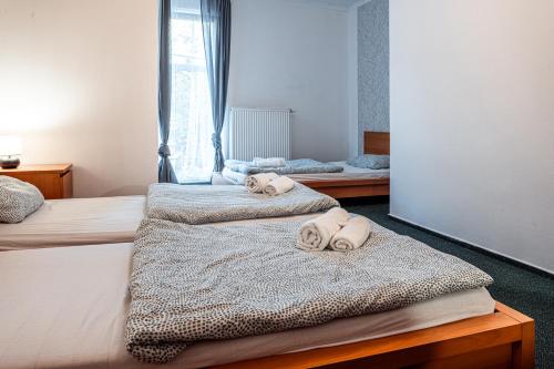 a bedroom with two beds with towels on them at Penzion Hurikán 63 in Havlickuv Brod