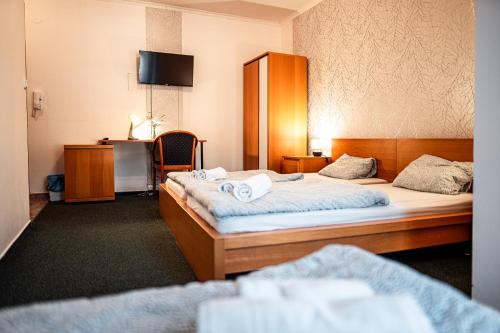 a hotel room with two beds with towels on them at Penzion Hurikán 63 in Havlickuv Brod