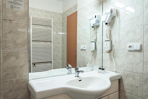 a bathroom with a white sink and a mirror at Penzion Hurikán 63 in Havlickuv Brod