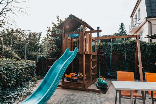 a playground with a slide and a play house at Penzion Hurikán 63 in Havlickuv Brod