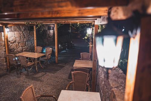 a restaurant with tables and chairs and a stone wall at Penzion Hurikán 63 in Havlickuv Brod