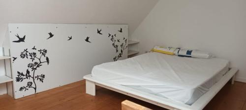 een kamer met een bed met vogels aan de muur bij Au coeur de mordelles in Mordelles
