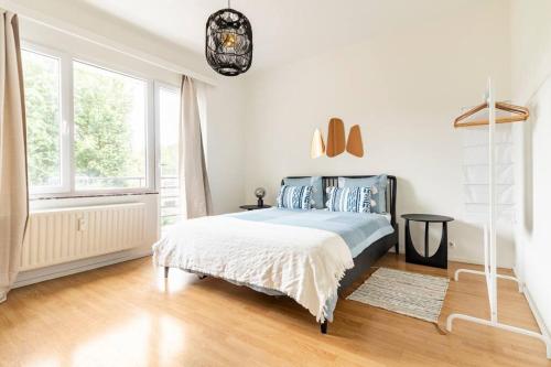 a white bedroom with a bed and a window at Cosy apart Antwerp city center1 in Antwerp