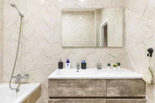 a bathroom with a sink and a mirror and a tub at Cosy apart Antwerp city center1 in Antwerp