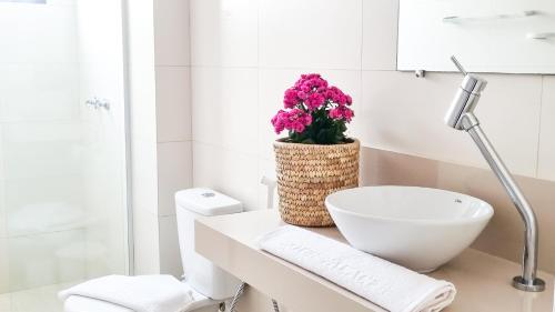un baño con lavabo y una flor en una encimera en Hotel Palace 1, en Florianópolis