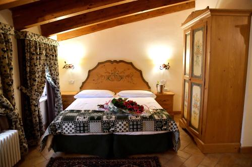 a bedroom with a bed with flowers on it at Garnì Astoria Hotel & SPA in Roccaraso