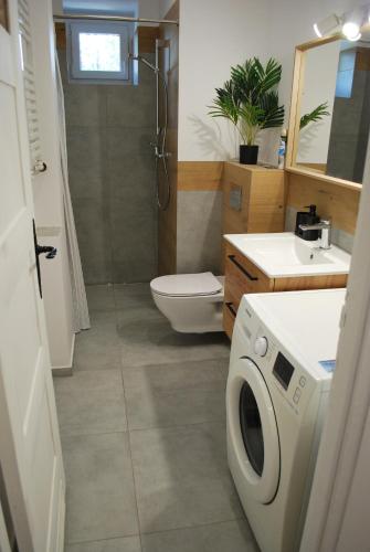 a bathroom with a washer and dryer in it at Baron Apartments Orientarium,Aquapark Fala & Park in Łódź
