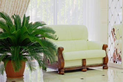 a white chair sitting next to a potted plant at Discovery Hotel in Bishkek