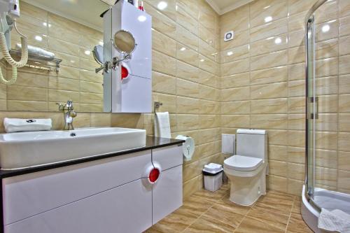 a bathroom with a sink and a toilet at Discovery Hotel in Bishkek