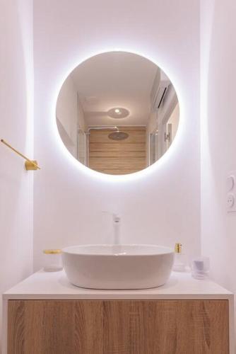 une salle de bain avec un lavabo blanc et un miroir dans l'établissement Le studio du 21- coeur de ville, à Bourg-en-Bresse