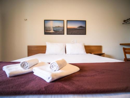 a bedroom with a large bed with towels on it at Pousada Reobote in São Miguel do Gostoso
