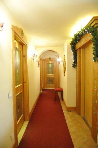 a hallway with a red carpet and two doors at Garnì Astoria Hotel & SPA in Roccaraso