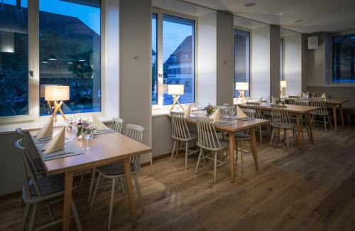 eine Reihe von Tischen in einem Restaurant mit Fenstern in der Unterkunft Hotel Sonnenhof Teinachtal in Neuweiler