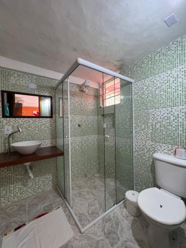 uma casa de banho com um chuveiro, um WC e um lavatório. em Suites Helena em Ilhabela