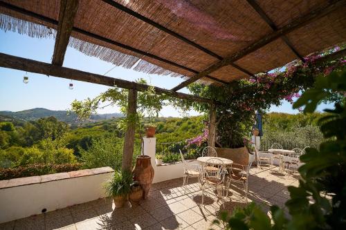 a patio with chairs and tables and a view at Villa Botero in Constantina