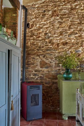 a room with a brick wall with a red and blue stove at Villa Botero in Constantina