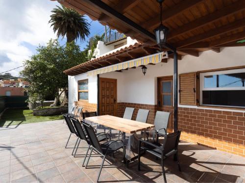 a wooden table and chairs on a patio at Live Tata Casa con jardin y vistas in Las Lagunas
