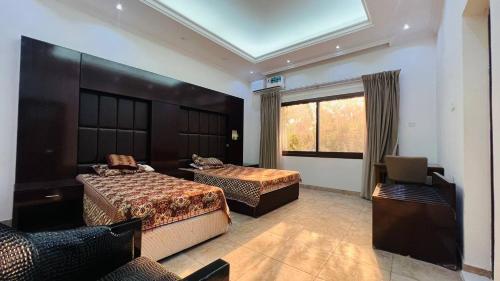 Habitación de hotel con 2 camas y ventana en Greenland Farm - Dubai Margham, en Dubái